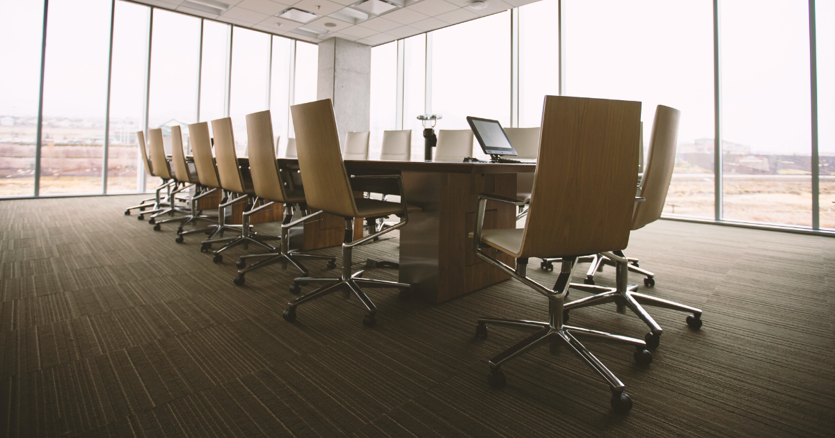 2023-2024 board member post graphic Executive board room table surrounded by windows